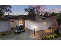 Charming single-story home featuring a golf cart, a pristine two-car garage and a well-kept stone landscaped yard at 427 Cambio Ct, The Villages, FL 32159