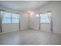 Bright living room featuring white walls, large windows, and a modern chandelier at 485 Pixie Ln, The Villages, FL 32162