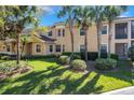 Inviting two-story townhome with lush landscaping, palm trees, and a welcoming entrance at 54 Camino Real Blvd # 504, Howey In The Hills, FL 34737