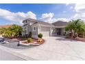 Charming house with a two-car garage, well-kept lawn, and a welcoming front porch area at 5551 Purslane Pl, The Villages, FL 32163