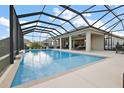 Screened-in pool area with a covered patio and ample seating provides a perfect oasis for relaxation at 712 Krietemeyer Path, The Villages, FL 32163
