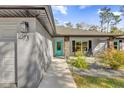 Inviting front entrance with a turquoise-colored door and stone accents at 73 Bay Dr, Ocklawaha, FL 32179