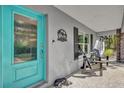Cozy front porch featuring stylish seating and a turquoise door at 73 Bay Dr, Ocklawaha, FL 32179