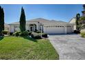 Charming single-story home boasts a three-car garage, a well-manicured lawn, and lush landscaping at 7812 Se 167Th Mistwood Ln, The Villages, FL 32162