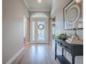Inviting foyer showcases a decorative front door, an elegant console table, and wood-look flooring at 7812 Se 167Th Mistwood Ln, The Villages, FL 32162