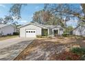 Charming single-story home featuring a one-car garage, well-maintained landscaping and bright white siding at 903 Dundee Cir, Leesburg, FL 34788