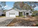 Charming single-story home featuring a one-car garage, well-maintained landscaping and bright white siding at 903 Dundee Cir, Leesburg, FL 34788