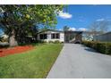 Single-story home featuring a well-manicured lawn and a long driveway at 915 Oleander St, Lady Lake, FL 32159
