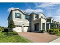 Charming two-story home featuring a three-car garage, brick driveway, and professionally landscaped front yard at 9729 Lost Creek Dr, Winter Garden, FL 34787