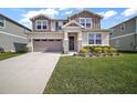 Charming two-story home with a well-manicured lawn and gray exterior with stone trim accents and a two car garage at 10177 Spring Lake Dr, Clermont, FL 34711