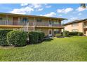 Two-story condominium building with manicured lawn, landscaping, and exterior staircases to the second level units at 1100 E Caroline St # 218, Tavares, FL 32778