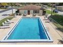 Aerial view of the community pool with lounge chairs and a peaceful setting at 12418 Clubhouse Ct, Tavares, FL 32778