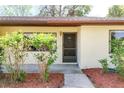 Close-up of the inviting front entry with mature landscaping at 12418 Clubhouse Ct, Tavares, FL 32778