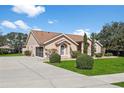 Spacious home with a side-entry garage, lush lawn, and mature landscaping providing great curb appeal at 12626 Douglas Fir Ct, Clermont, FL 34711