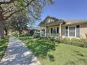 Exterior view of home showcasing a beautiful lawn, sidewalk and front porch with columns at 12919 Freeman St, Windermere, FL 34786