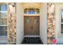 Inviting front double doors with welcome wreaths and elegant stone accents at 13800 Wellington Ln, Grand Island, FL 32735