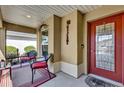 Welcoming screened porch with elegant door, tasteful decorations, and comfortable chairs at 16801 Se 74 Soulliere Ave, The Villages, FL 32162