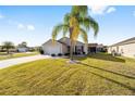 Attractive home boasts a palm tree, neat lawn, a two-car garage, and a screened patio at 2046 Dalecroft Trl, The Villages, FL 32162