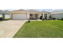 Charming single-story home with lush green lawn and stone driveway at 2114 Gerardo Ave, The Villages, FL 32159