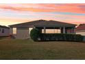 A cozy back exterior featuring a covered patio, serene views, and lush green lawn at 2311 Bramble Ter, The Villages, FL 32162