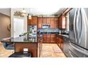 A well-equipped kitchen with dark wood cabinets, a tiled backsplash, and stainless steel appliances at 26747 White Plains Way, Leesburg, FL 34748