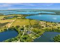 Wide aerial shot of a vast lakefront property, showing the home's location within a beautiful natural landscape at 27852 Lake Jem Rd, Mount Dora, FL 32757