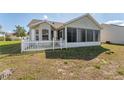 Exterior view of a home featuring a screened porch and white picket fence in the backyard at 3009 Batally Ct, The Villages, FL 32162