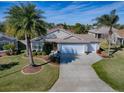 Aerial view of a well-maintained home with a manicured lawn, lush landscaping and a three-car garage at 3142 Islawild Way, The Villages, FL 32163