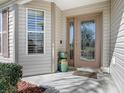 Beautiful front entrance featuring a decorative glass door, sidelight, and manicured landscaping at 3142 Islawild Way, The Villages, FL 32163