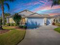 Inviting home featuring a well-kept lawn, mature landscaping, and a spacious three-car garage at 3142 Islawild Way, The Villages, FL 32163