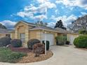 Charming one-story home boasts a manicured lawn, mature landscaping, and a welcoming entrance, creating a delightful curb appeal at 3285 Archer Ave, The Villages, FL 32162