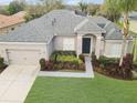 Aerial view of a charming single-story home featuring a lush green lawn and mature landscaping at 3435 Tumbling River Dr, Clermont, FL 34711