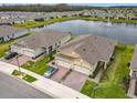 Beautiful aerial view of a well-maintained home with lush greenery and a serene lake backdrop at 3449 Meadow Beauty Way, Clermont, FL 34714