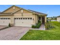 Charming home featuring a brick driveway, a two-car garage, and manicured landscaping at 3449 Meadow Beauty Way, Clermont, FL 34714