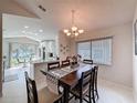 Open-concept dining room with modern chandelier and large window at 3720 Eversholt St, Clermont, FL 34711