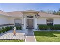 Inviting front entrance with decorative landscaping and neutral color scheme at 377 Ed Douglas Rd, Groveland, FL 34736