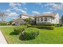 Charming home exterior with neatly trimmed hedges and vibrant green lawn at 4256 Fawn Meadows Cir, Clermont, FL 34711