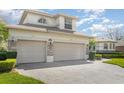 Large three-car garage with stone accents and a well-maintained driveway at 4256 Fawn Meadows Cir, Clermont, FL 34711