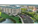 Condo building with mature landscaping, pond views, and parking at 4620 Riverwalk Village Ct # 7505, Ponce Inlet, FL 32127