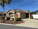 Inviting single-story home featuring a well-kept yard, attached garage, and a neatly curved driveway at 483 Cammarano Pl, The Villages, FL 32162