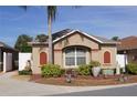 A charming single-story home features a well-manicured lawn with lush shrubs and a decorative palm tree at 483 Cammarano Pl, The Villages, FL 32162