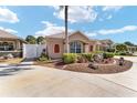 Beautiful front yard with mature landscaping, stone features, garden, and two-car garage at 483 Cammarano Pl, The Villages, FL 32162