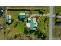 An aerial view shows the home and the detached garage with a matching roof and landscaping at 4940 County Road 134B, Wildwood, FL 34785