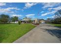 Charming home with a long driveway, detached garage, manicured lawn, and American flag at 4940 County Road 134B, Wildwood, FL 34785