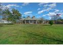 A single-story home boasts a spacious front yard with well-maintained landscaping and a vibrant green lawn at 4940 County Road 134B, Wildwood, FL 34785