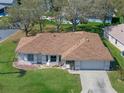 Aerial view of a well-maintained home with a lush green lawn, mature trees, and tidy landscaping at 5533 Squires Dr, Leesburg, FL 34748