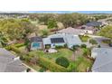 Aerial view of the home's backyard, featuring a screened-in pool, lush landscaping, and a clear view of the golf course at 589 Society Hill Cir, The Villages, FL 32162