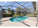 Beautiful screened-in pool area with a water feature and a view of the lush green landscaping and golf course at 589 Society Hill Cir, The Villages, FL 32162