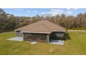 Back exterior of the house with screened-in porch and grill on the back patio at 5890 Sw 167Th Pl, Ocala, FL 34473