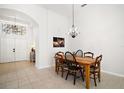 Bright dining room with modern light fixture and tile floors that connect to the open-concept floorplan at 6035 Falconbridge Pl, Mount Dora, FL 32757